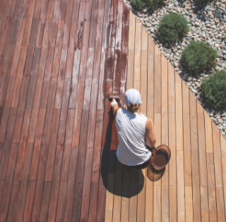 femme entretenant une terrasse en bois avec saturateur