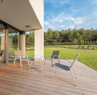 terrasse en bois sur plots ensoleillée avec salon de jardin